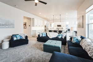 Living room featuring a textured ceiling, recessed lighting, baseboards, and light carpet