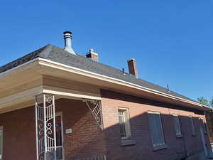View of home's exterior featuring brick siding and a chimney