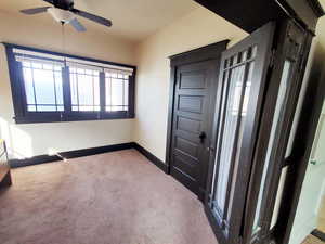 Interior space with ceiling fan, baseboards, and carpet