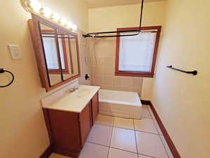 Full bathroom with vanity, tile patterned floors, baseboards, and  shower combination