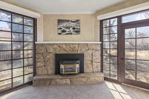 Room details with crown molding, a wood stove, and carpet