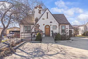 English style home with stucco siding and a shingled roof