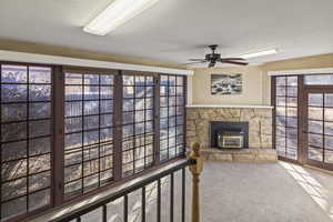 Living room featuring a wealth of natural light, a textured ceiling, and carpet