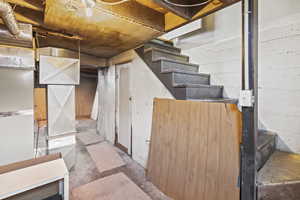 Unfinished below grade area featuring stairway
