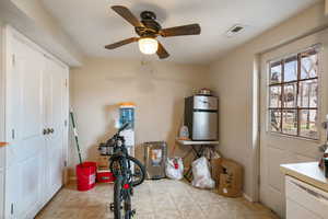 Miscellaneous room with ceiling fan, light tile patterned floors, visible vents, baseboards, and water heater