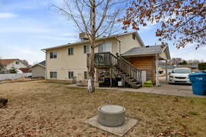 Rear view of property featuring a lawn and fence