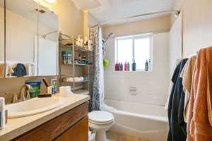 Bathroom with visible vents, toilet, shower / bath combo, vanity, and tile patterned floors