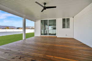 Wooden deck featuring a mountain view and a ceiling fan