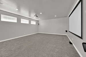 Cinema room with light carpet, recessed lighting, and a textured ceiling