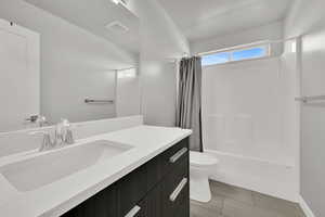 Bathroom with shower / bath combination with curtain, vanity, and light tile patterned flooring