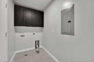Laundry area with electric panel, cabinet space, hookup for an electric dryer, and washer hookup