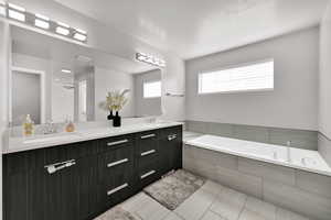 Master Bathroom with double vanity, garden tub, and light tile patterned floors