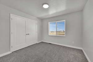 Bedroom #3 featuring carpet, a closet, and a textured ceiling