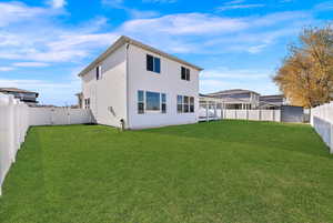 Back of house with a fenced backyard and a gate