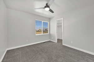 Bedroom #2 featuring carpet, a walk in closet, ceiling fan, and a textured ceiling