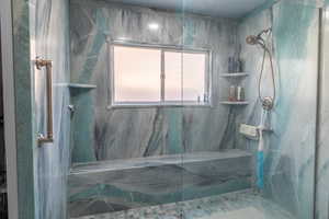 Full bath featuring a marble finish shower