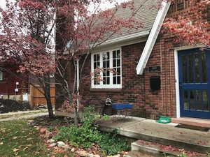 View of side of home with brick siding and roof with shingles