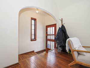 Entryway featuring baseboards, arched walkways, and wood-type flooring