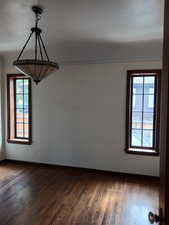 Spare room with dark wood-style floors and baseboards