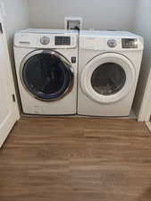 Laundry room featuring laundry area, wood finished floors, and independent washer and dryer