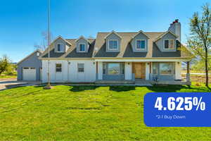 Cape cod home with a front yard, a shingled roof, driveway, a chimney, and an attached garage