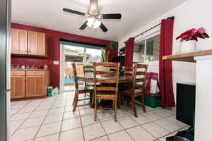 Dining space with ceiling fan and light tile patterned flooring