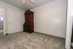 Unfurnished bedroom with a closet, a ceiling fan, and light colored carpet