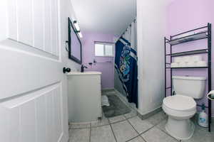 Bathroom with tile patterned flooring, vanity, and toilet