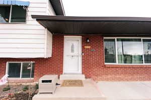 View of exterior entry with brick siding