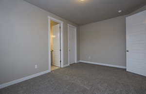 Spare room featuring carpet and baseboards