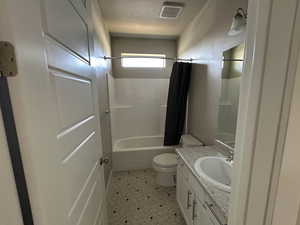 Full bath featuring visible vents, toilet, a textured ceiling, shower / tub combo, and vanity