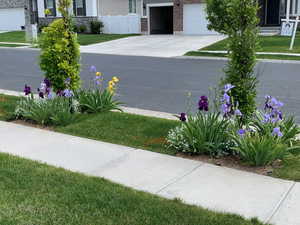 Exterior space with a garage, concrete driveway, and fence