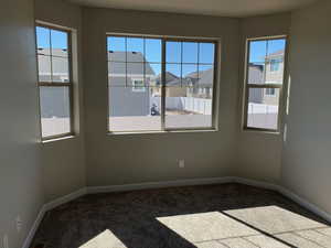 Carpeted spare room with baseboards