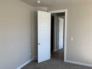 Unfurnished bedroom with visible vents, baseboards, and carpet