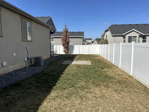 View of yard featuring a residential view, central AC unit, and a fenced backyard