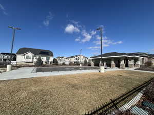 View of property's community featuring a residential view, a lawn, and fence