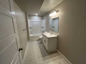 Bathroom with vanity, baseboards, tub / shower combination, tile patterned floors, and toilet