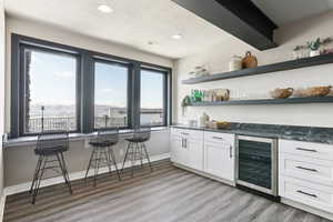 Bar with a bar, wine cooler, a healthy amount of sunlight, and visible vents