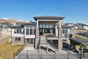 Back of property with stucco siding, a patio, a yard, and a fenced backyard