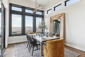 Dining area featuring visible vents, a high ceiling, baseboards, and wood finished floors