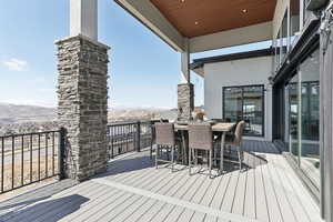 Deck with outdoor dining area and a mountain view