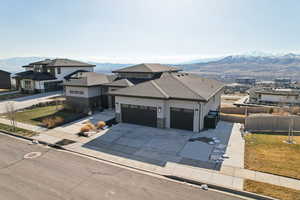 View of front of home featuring a mountain view, a garage, driveway, and fence