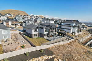 View of front of house with a mountain view, a residential view, a fenced backyard, and a patio area