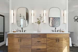 Bathroom with double vanity, baseboards, and a sink