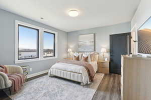 Bedroom with visible vents, baseboards, and wood finished floors