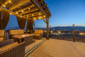Wooden terrace featuring an outdoor living space with a fire pit, a pergola, and a mountain view