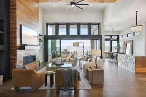 Living area with a high ceiling, a fireplace, dark wood-style flooring, and a healthy amount of sunlight