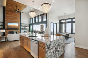 Kitchen featuring brown cabinets, a fireplace, a sink, dark wood-type flooring, and open floor plan
