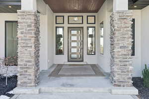 View of exterior entry featuring a porch and stucco siding