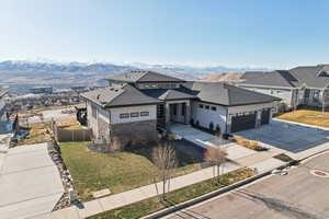 View of front of home featuring a mountain view, an attached garage, driveway, and fence